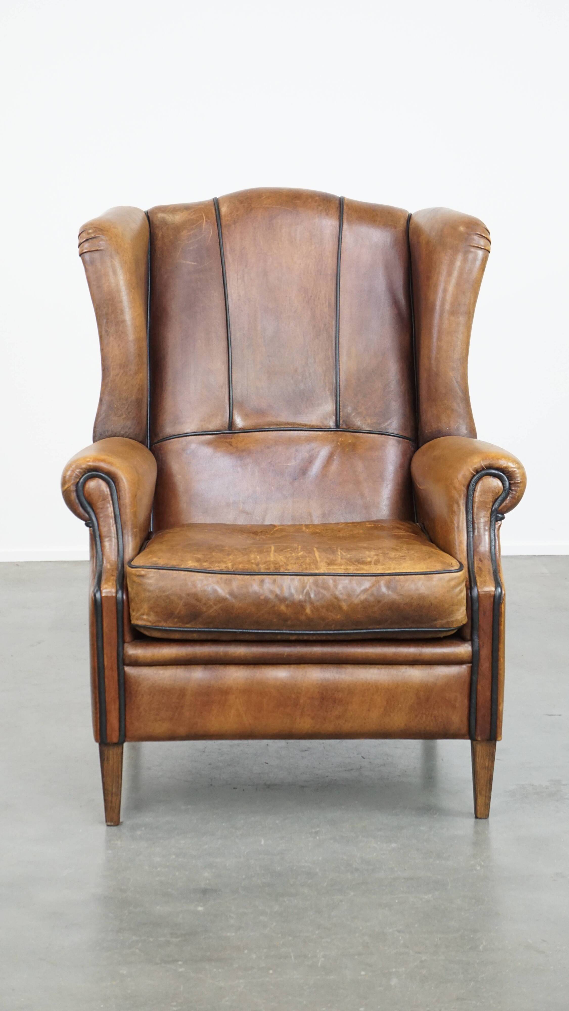 Sheep leather wingback chair finished with black piping