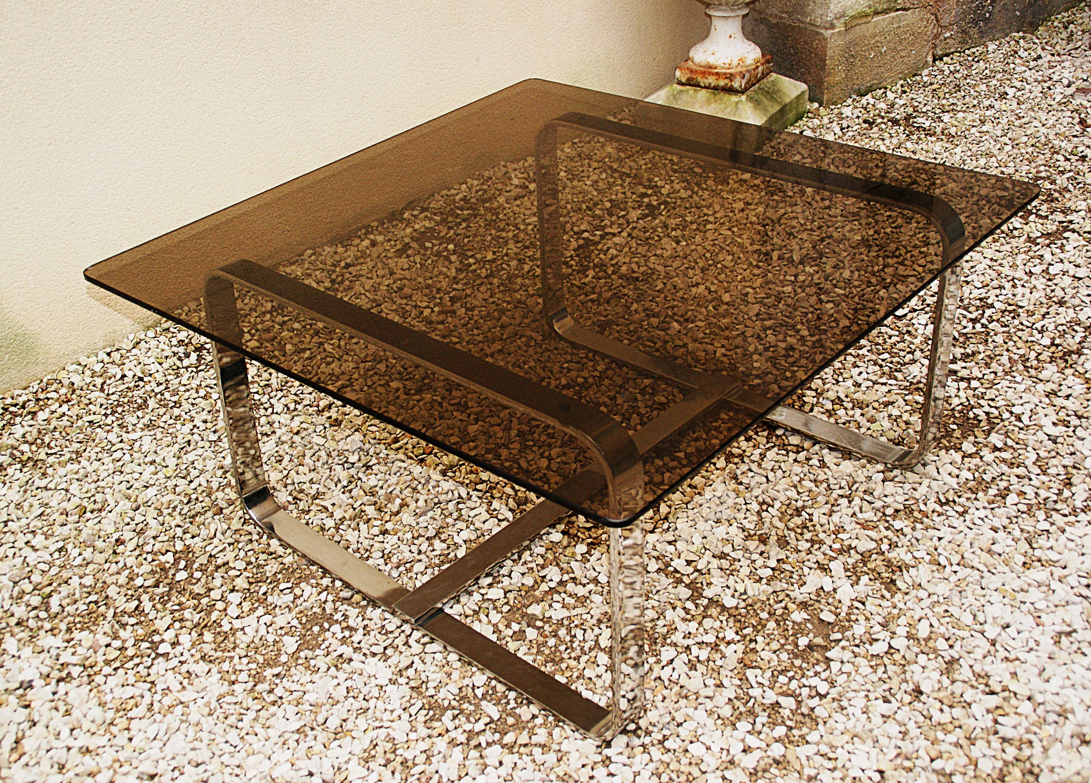Table basse Roche Bobois 1970 verre fumé piètement en métal chromé.