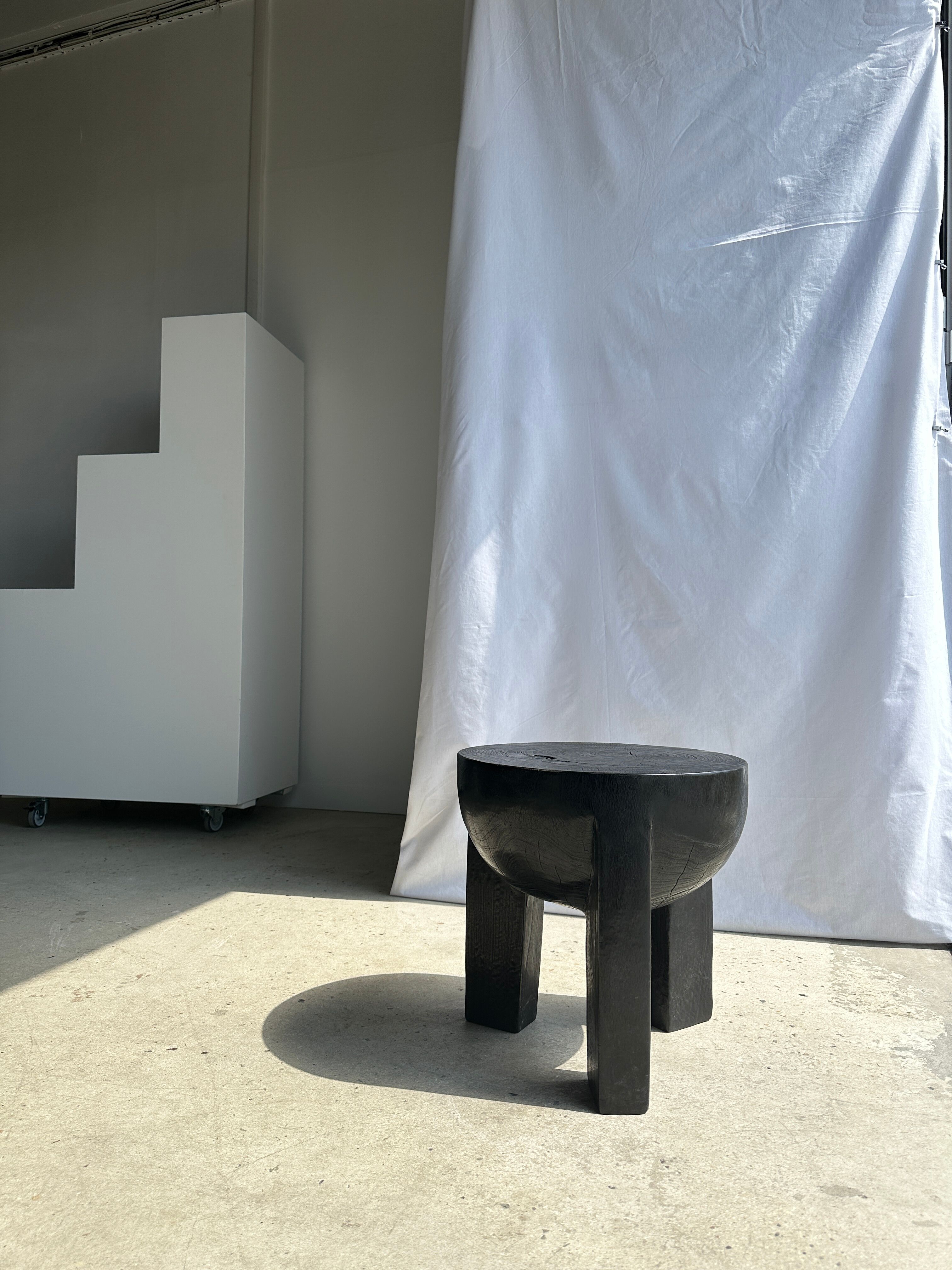 Black mango wood tripod side table with a semi-spherical top, height: 45 cm, diameter: 44 cm.