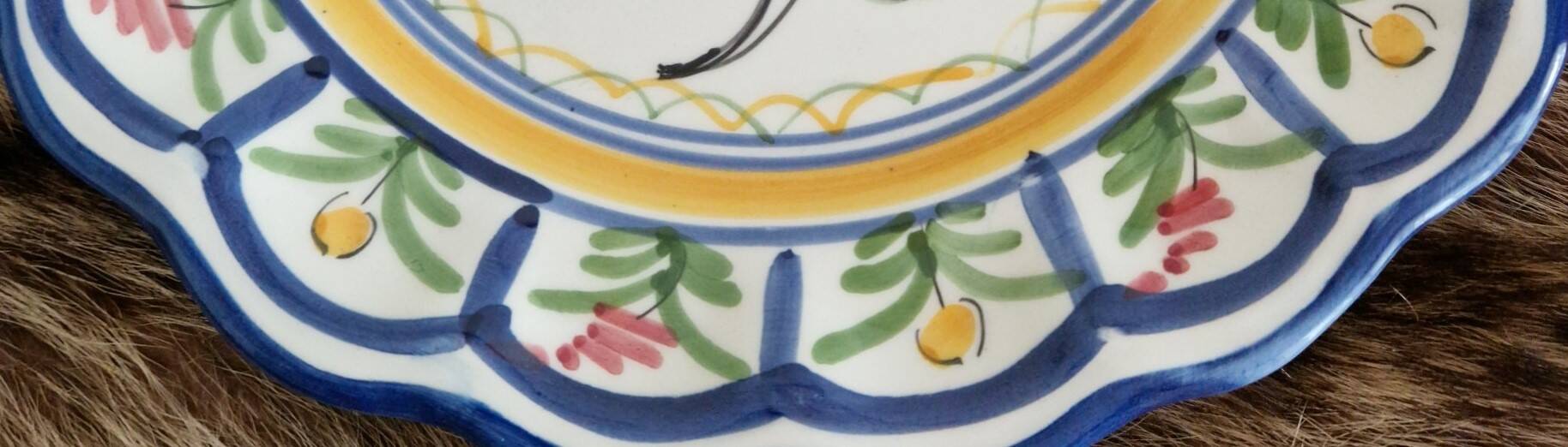 Large hand-painted French faience plate with floral decoration in folk art style.