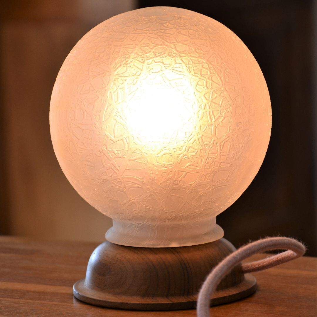 White glass globe table lamp with geometric reliefs