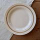 Round vintage ivory earthenware serving dish with double gold trim.