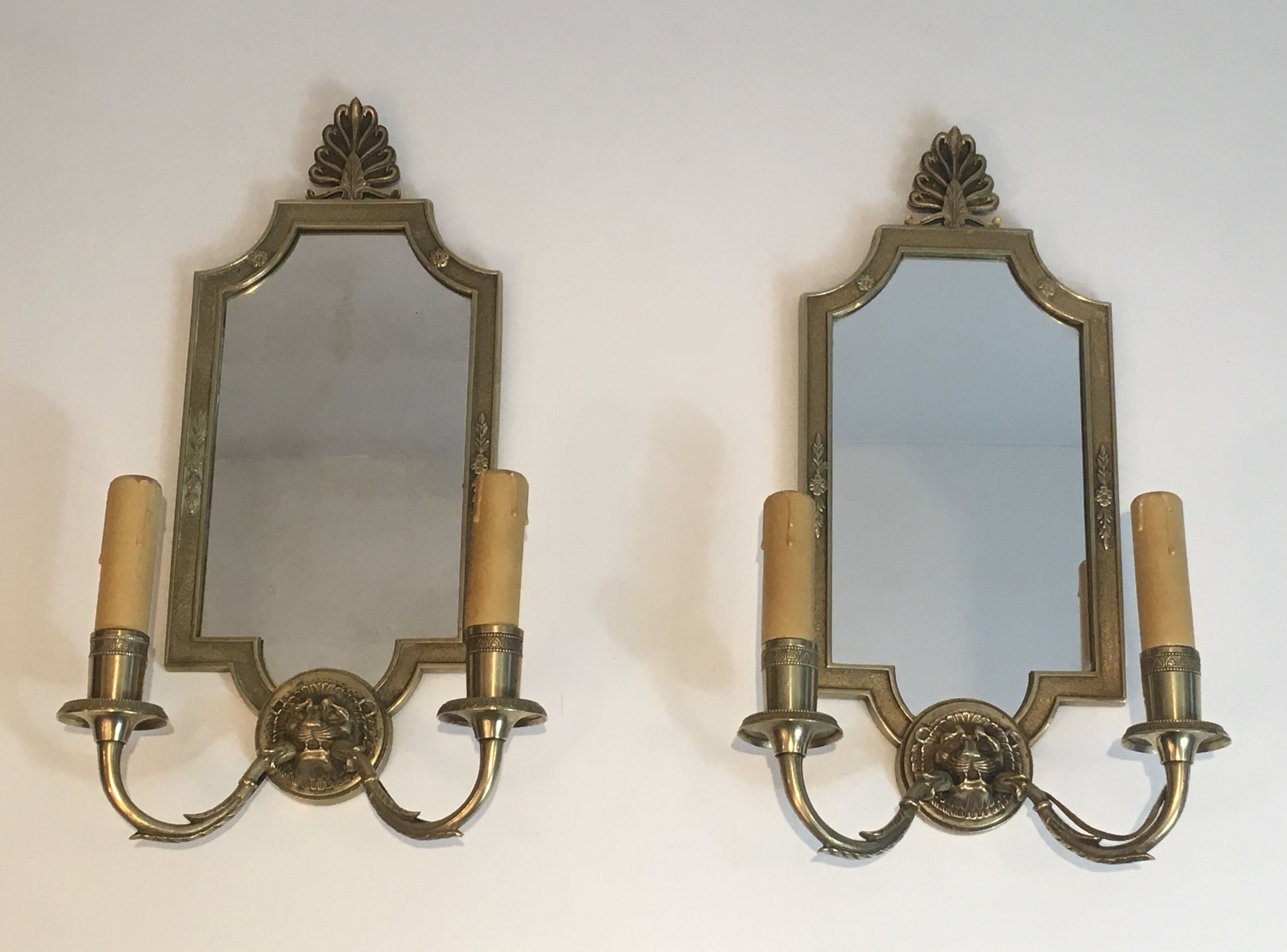 Pair of mirror and bronze wall lamps with lions' heads, french work. around 1940