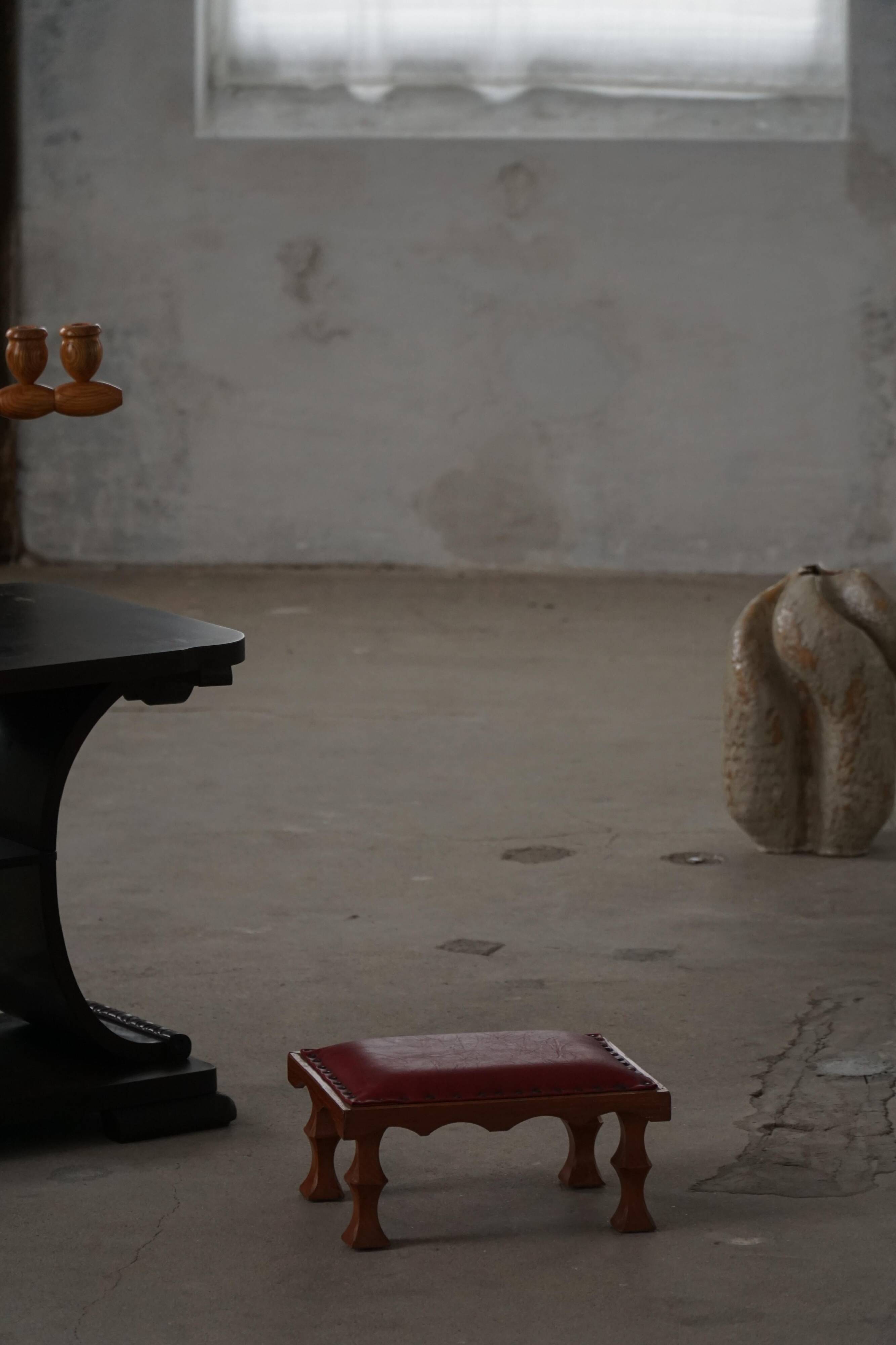 Danish sculpted oak stool from the mid-20th century with a red leather seat, 1950s.