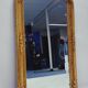 Grand miroir baroque en or avec un crête orné.