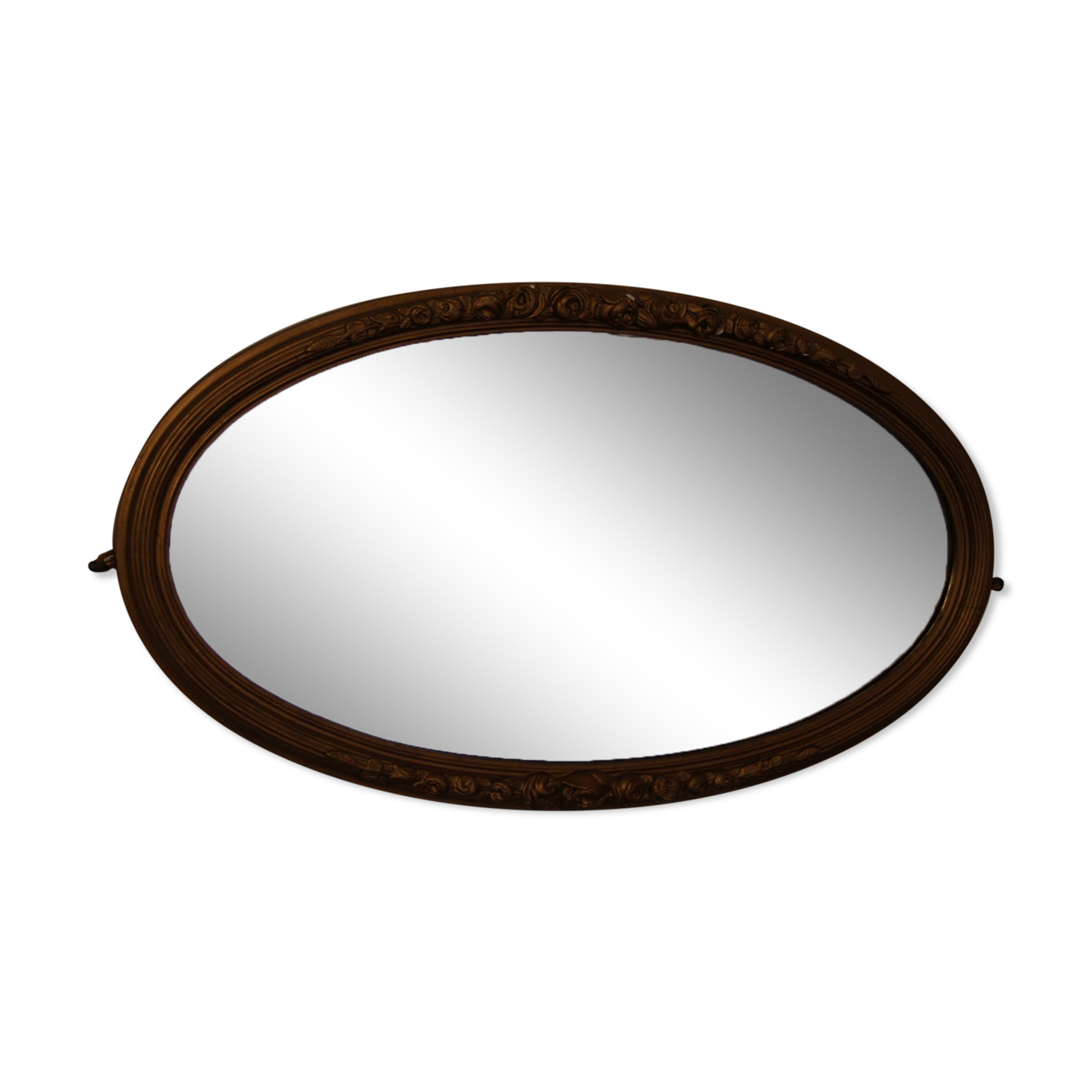 Beveled oval mirror in gilded wood