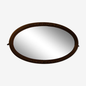Beveled oval mirror in gilded wood