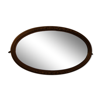 Beveled oval mirror in gilded wood