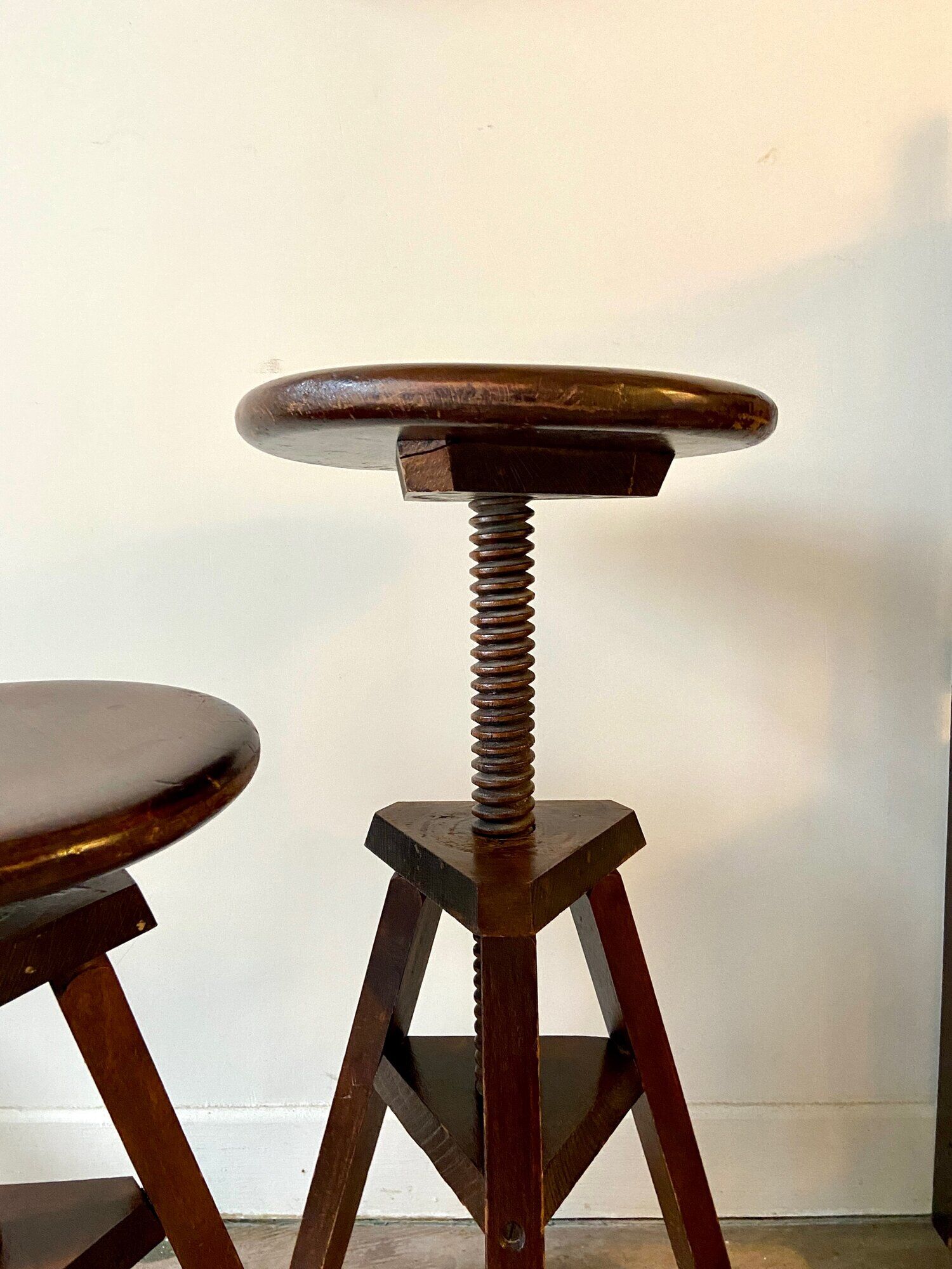2 tripod stools with dark wood screws