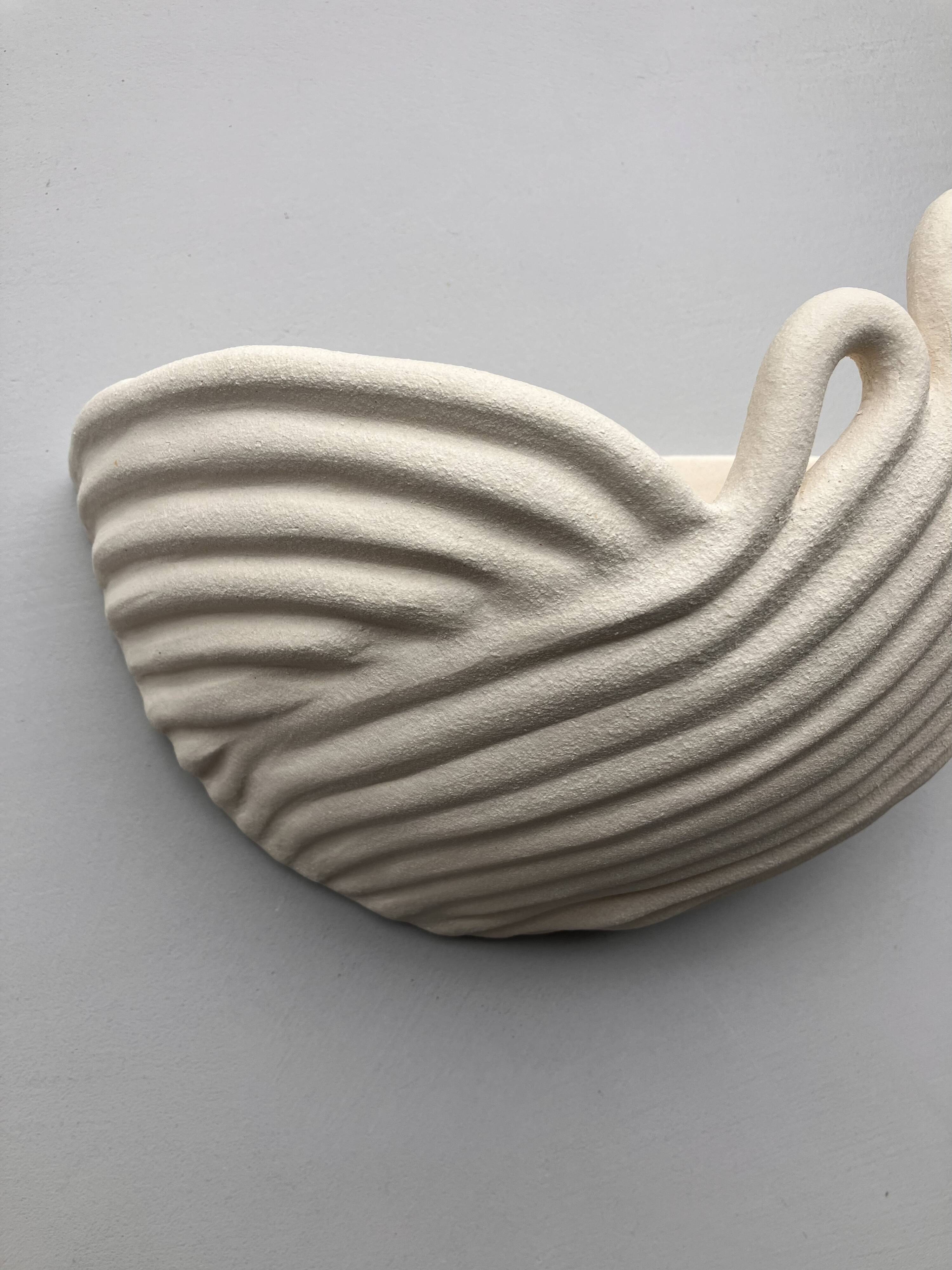Draped ceramic wall light in a half-moon shape.