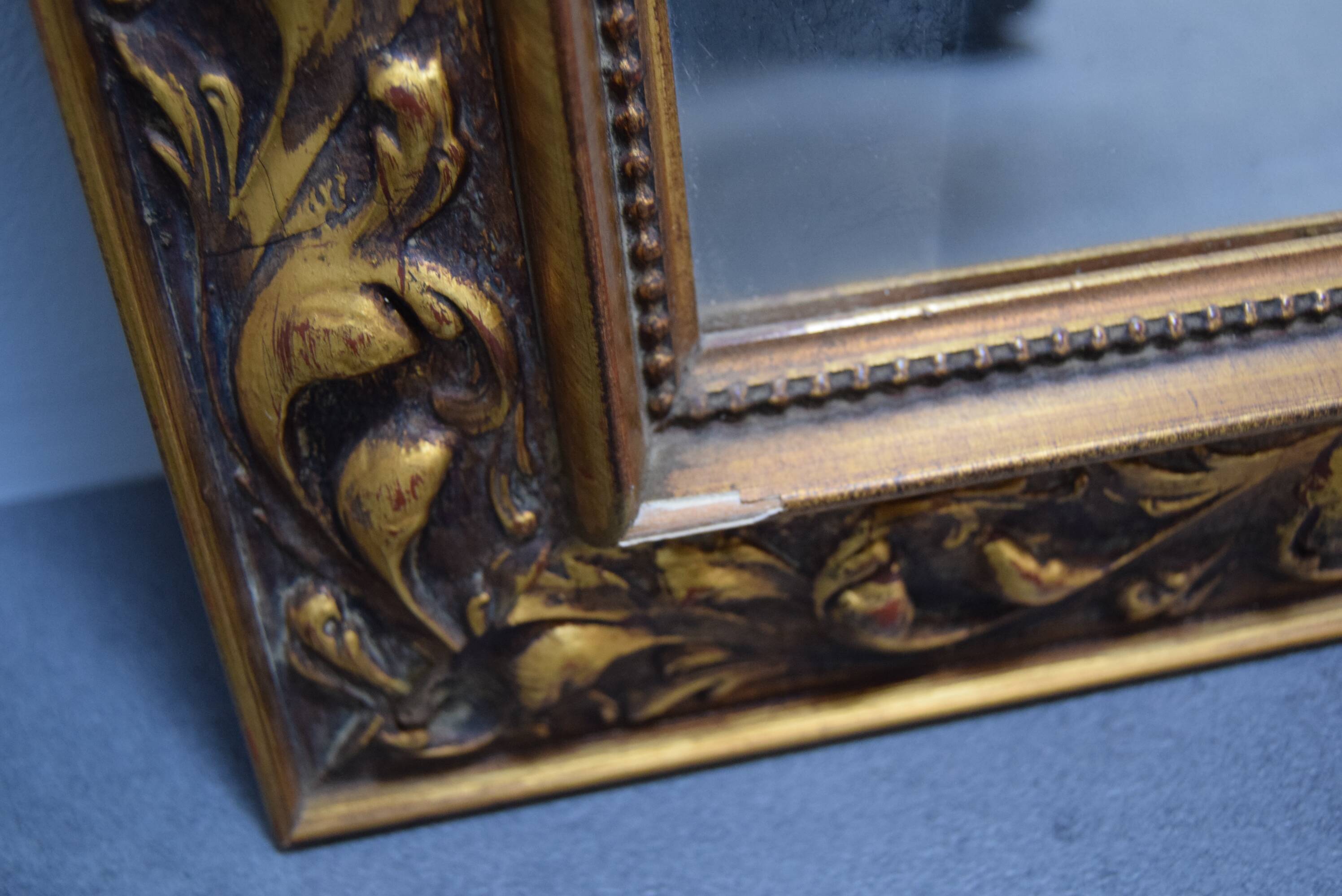 wall mirror in a decorative wooden frame.