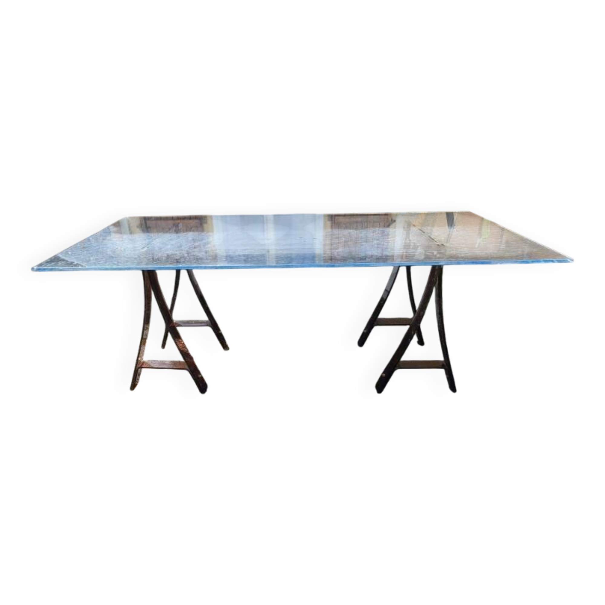 Vintage table with a glass top and smoked plastic trestle legs.
