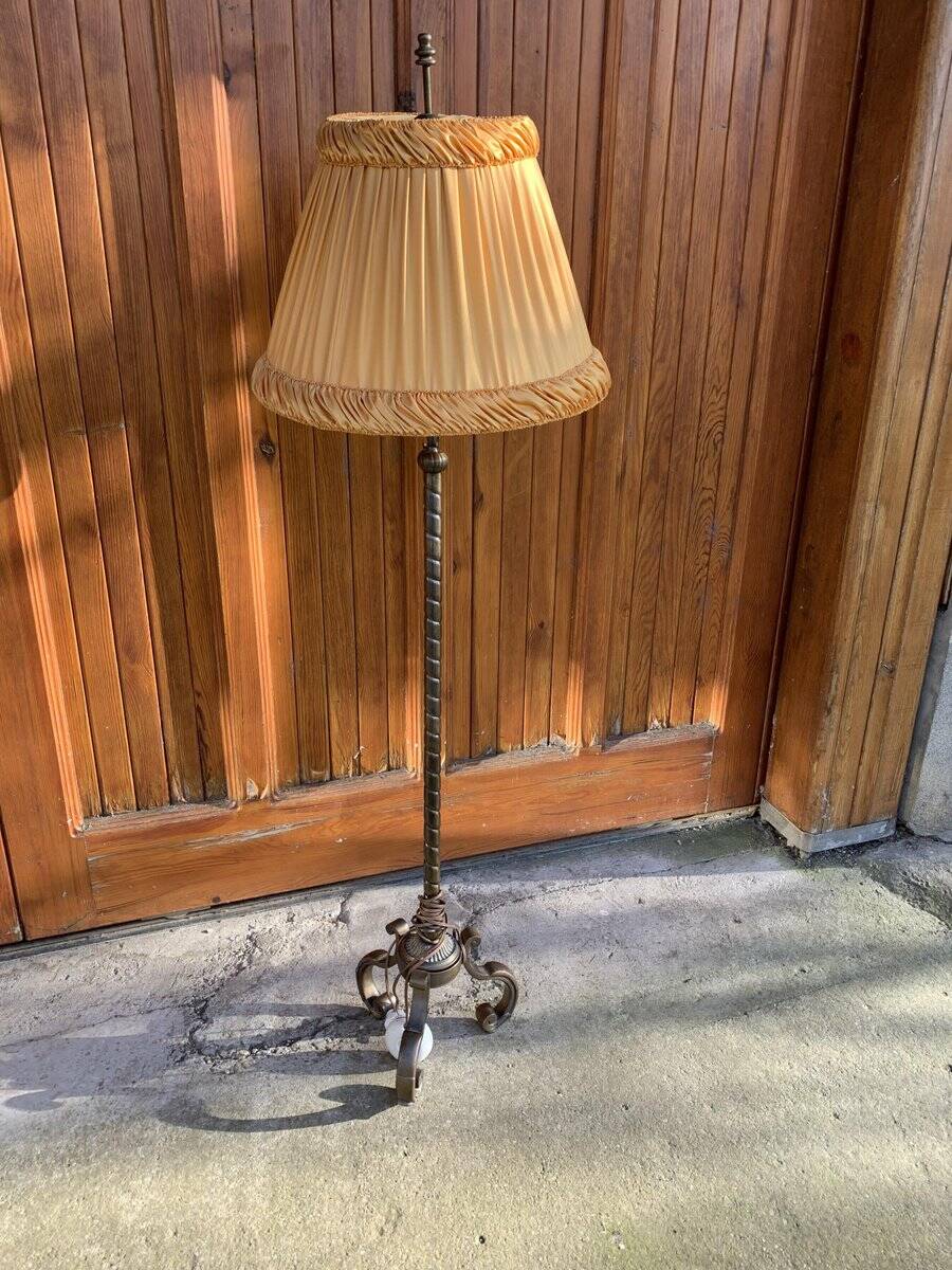 Art Deco floor lamp in bronze metal with a straw yellow fabric shade, twisted shaft, and tripod base.