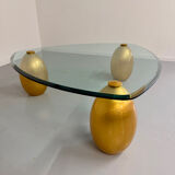 Vintage Italian design coffee table with a glass top and gold base, dating from the 1980s.