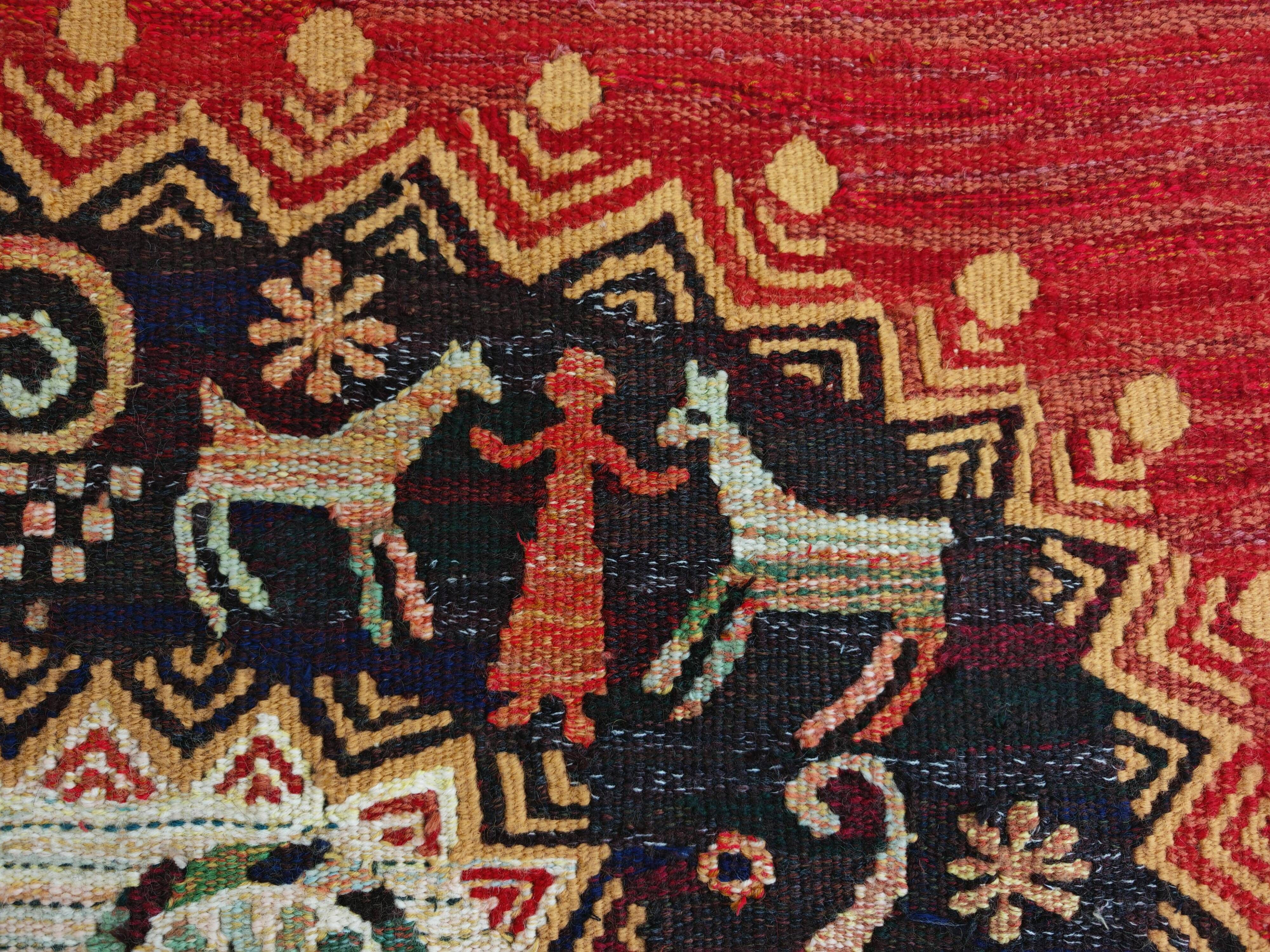 Vintage handwoven tapestry with a folk scene and archaic Slavic writing.