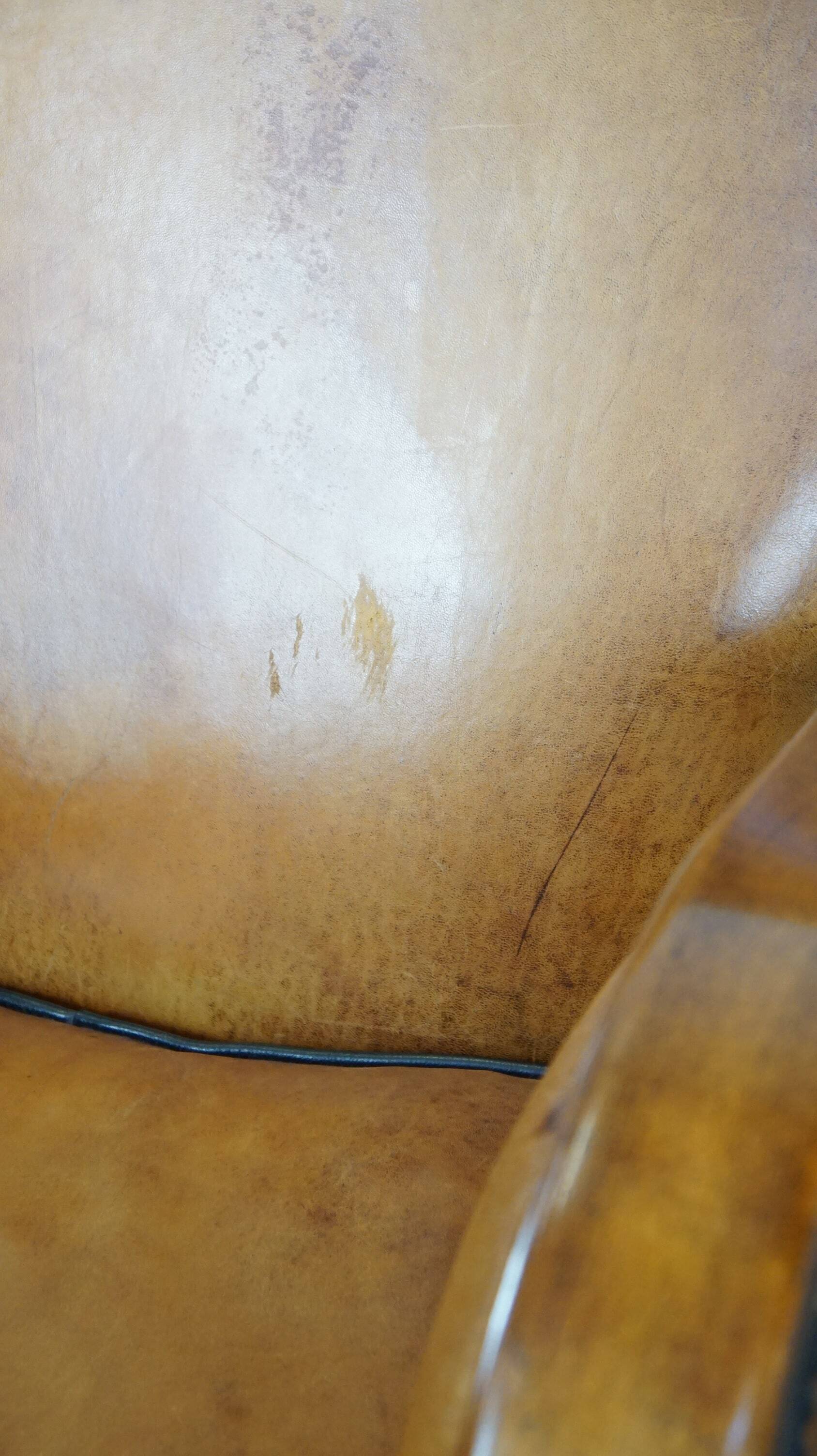 Unique, luxurious sheepskin armchair combined with wood and finished with decorative nails