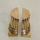 A pair of brass bookends representing columns.