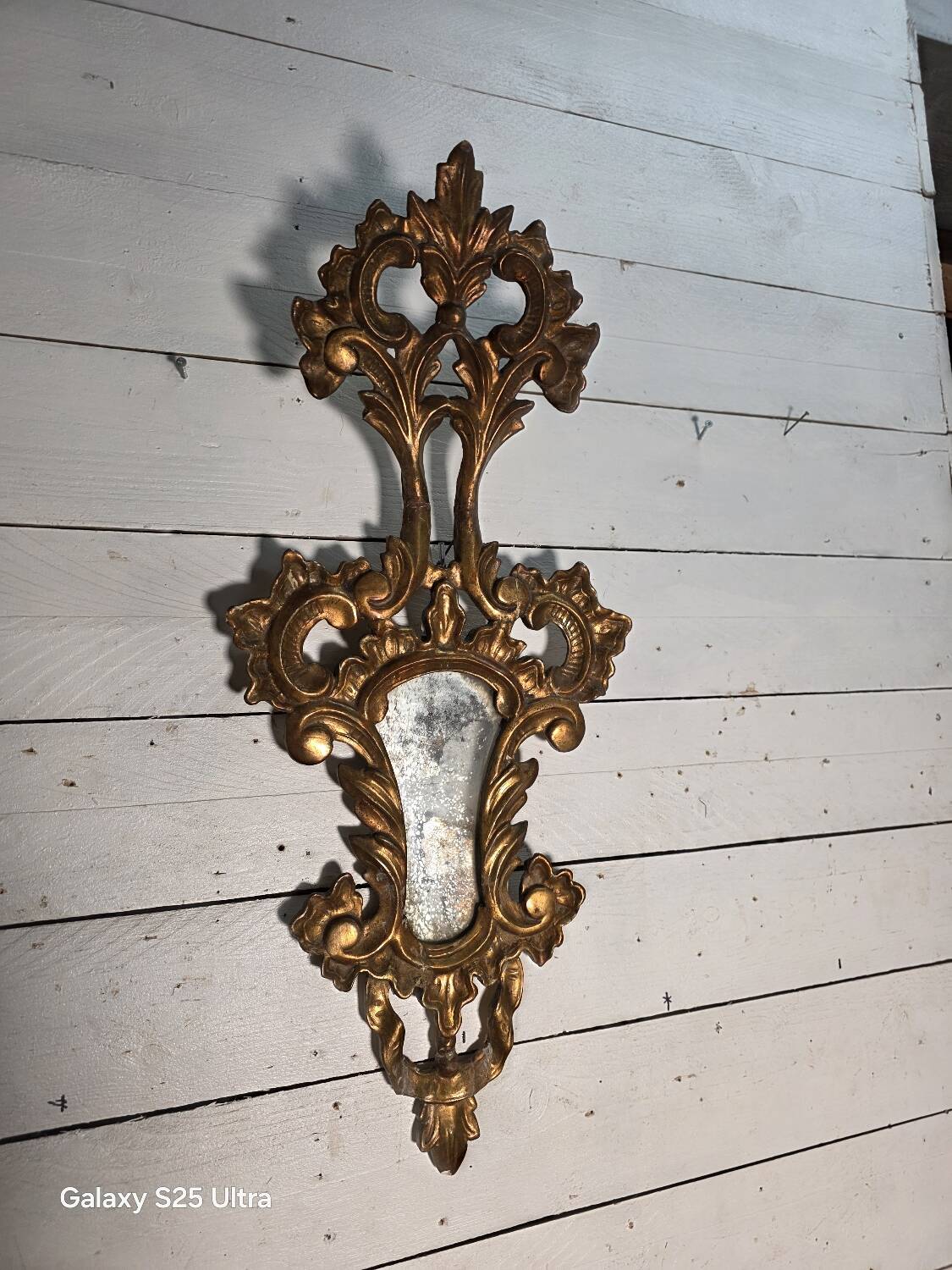 Italian mirror in gilded wood with gold leaf from the 18th century.