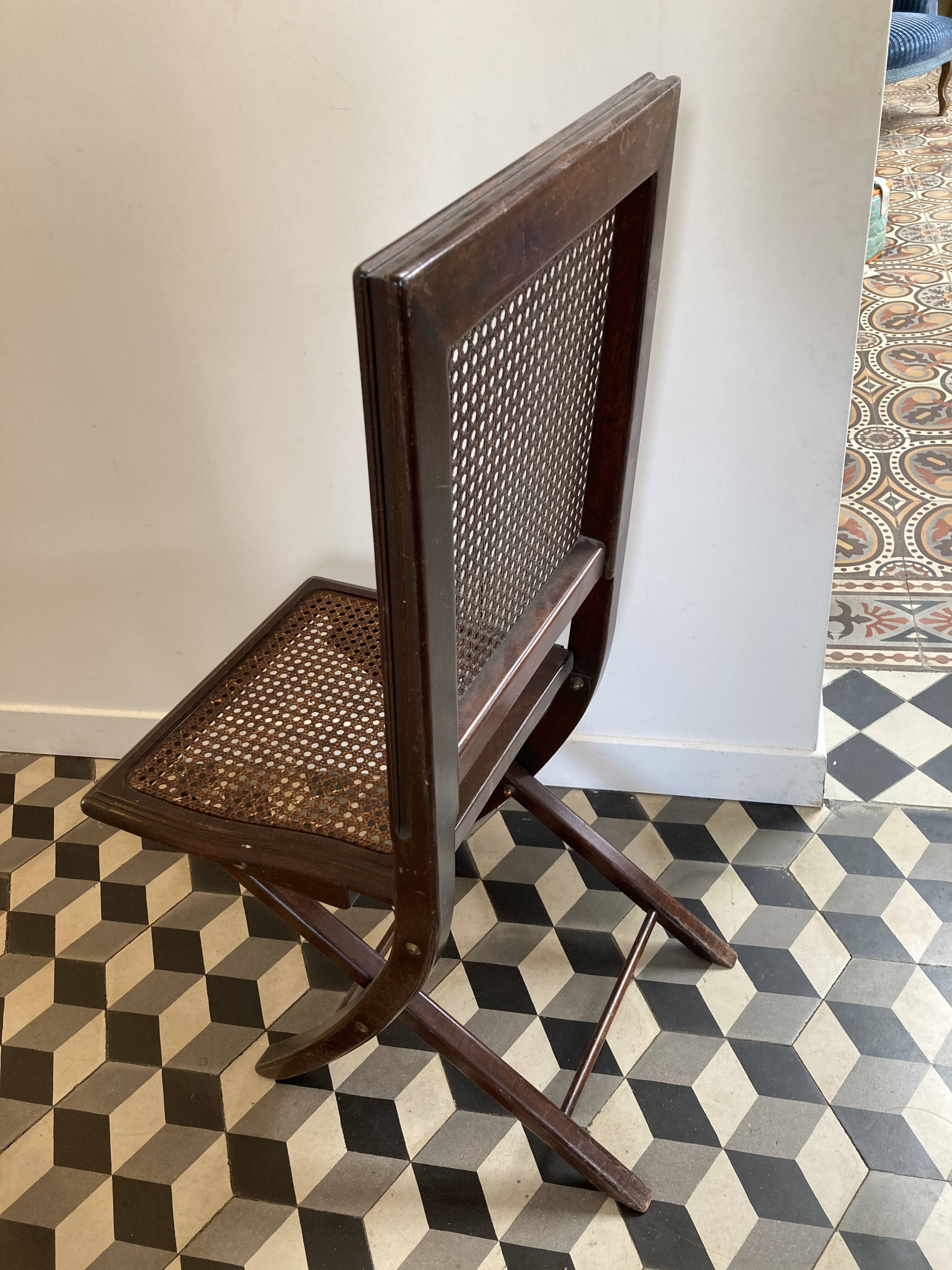 Vintage folding chair with cane seat in dark mahogany wood