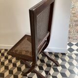 Vintage folding chair with cane seat in dark mahogany wood