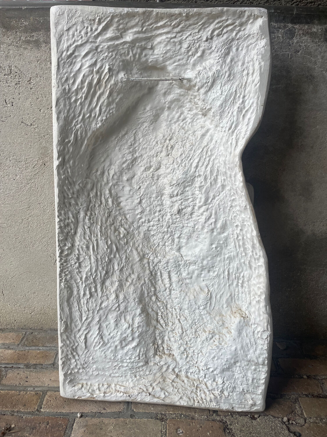 Ancient plaster bas-relief of Nike fastening her sandal.