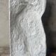 Ancient plaster bas-relief of Nike fastening her sandal.
