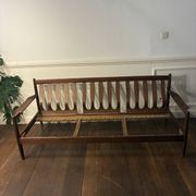 Vintage 3-seater wooden sofa with sculptural backrest.