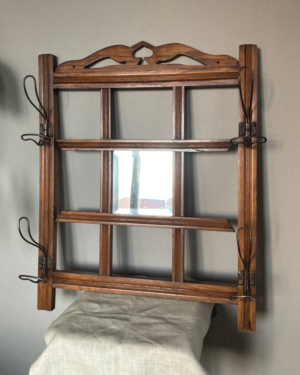 Art Deco wall-mounted coat rack in oak, early 20th century. Beveled central mirror