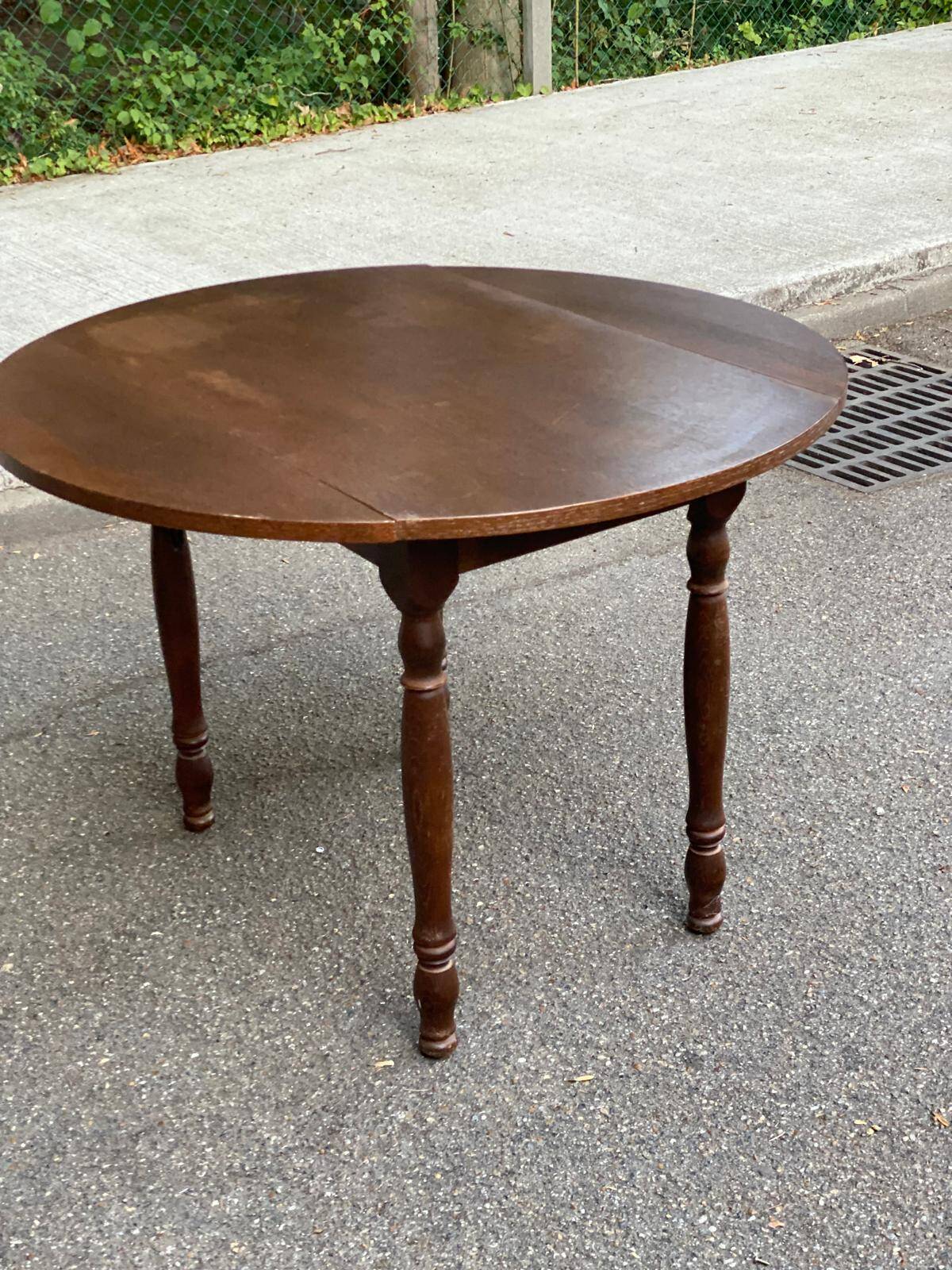 Round kitchen or dining table with extendable leaves in dark wood.