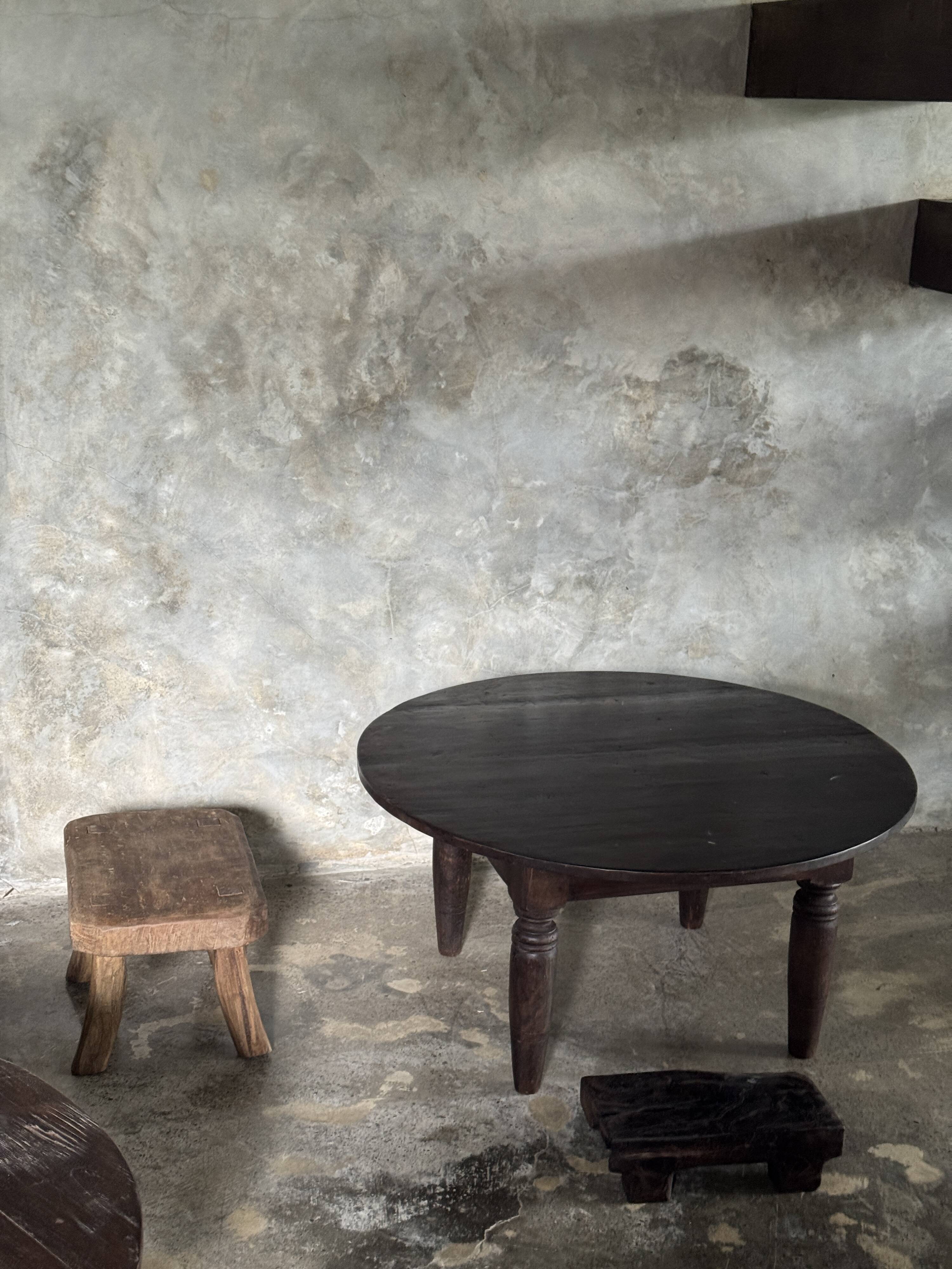 Antique round coffee table in Indonesian teak with turned legs.