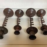Four twisted metal candle holders with a rusty appearance