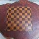 Brutalist chessboard coffee table made from tree stump.