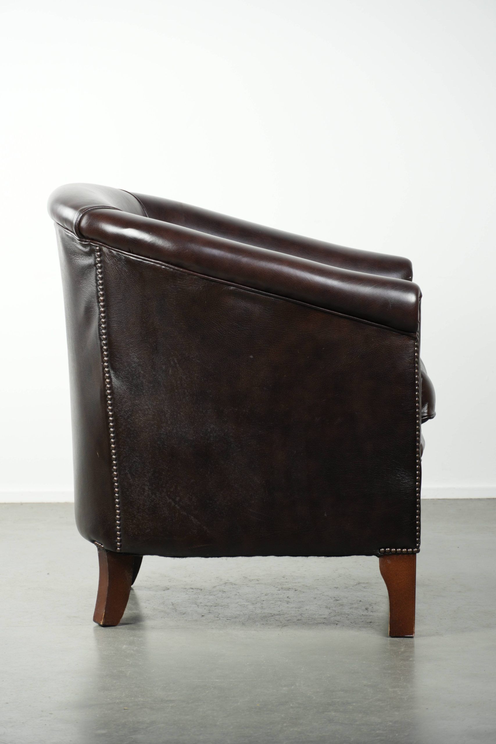 Dark cow leather club armchair with a stylish design in English style