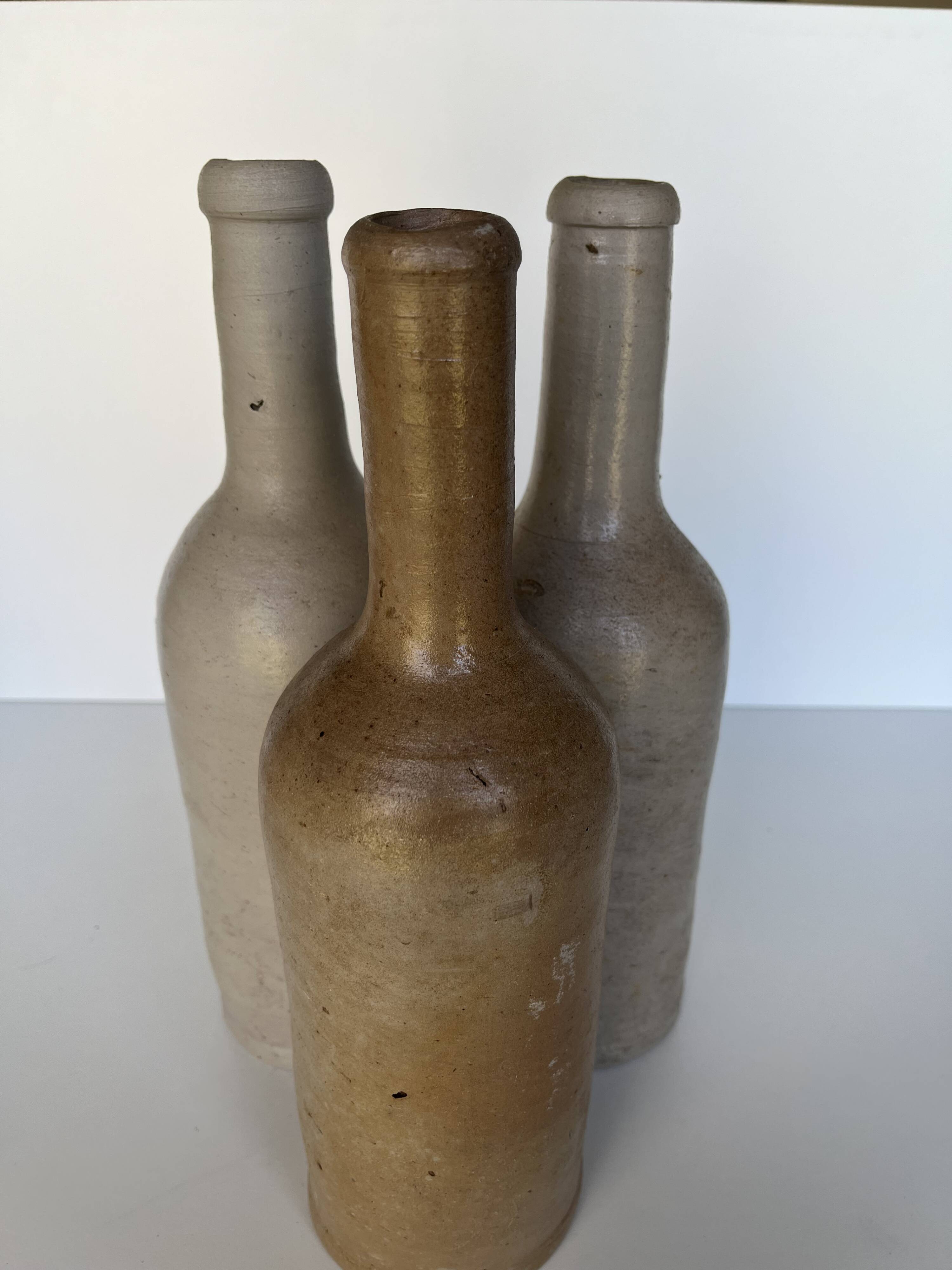 Trio of antique matte stoneware bottles