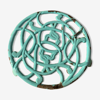 Old trivet in blue green enamelled cast iron with chiseled birds, round format
