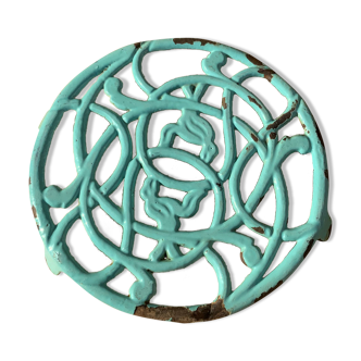 Old trivet in blue green enamelled cast iron with chiseled birds, round format