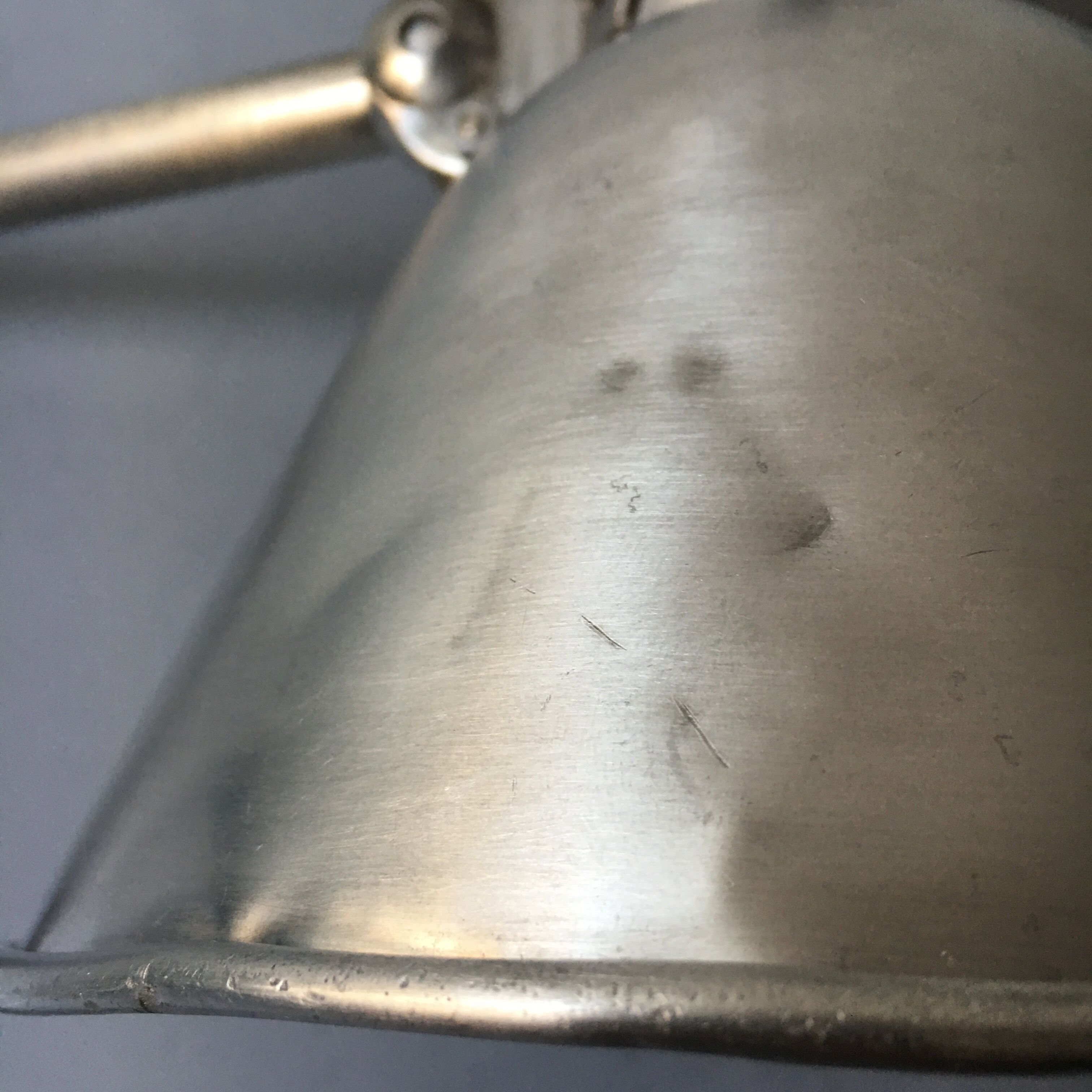 Old industrial lamp has vise 'mazda '.