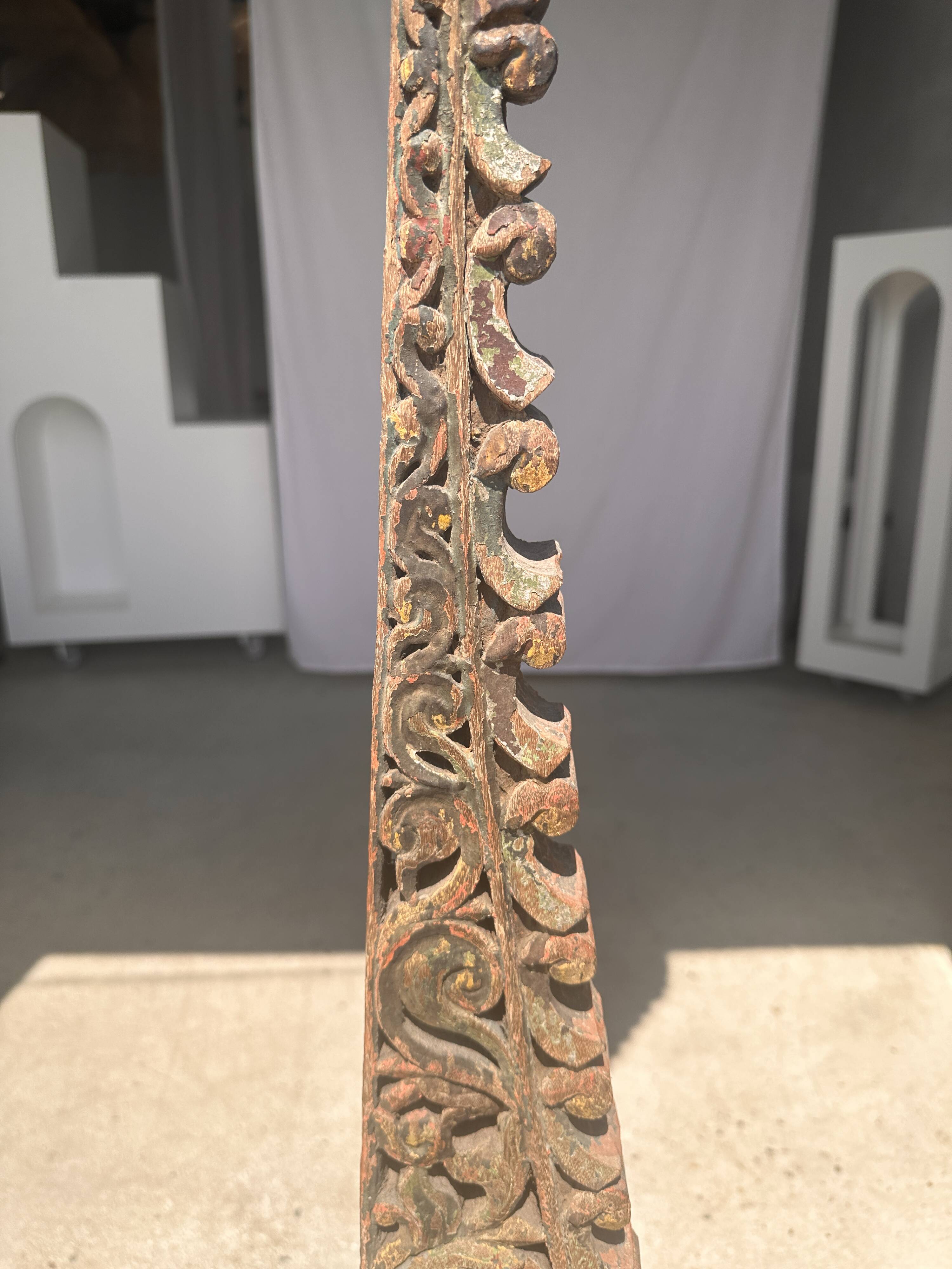 Indonesian construction element in carved wood with intertwined plant motifs mounted on a base (fri