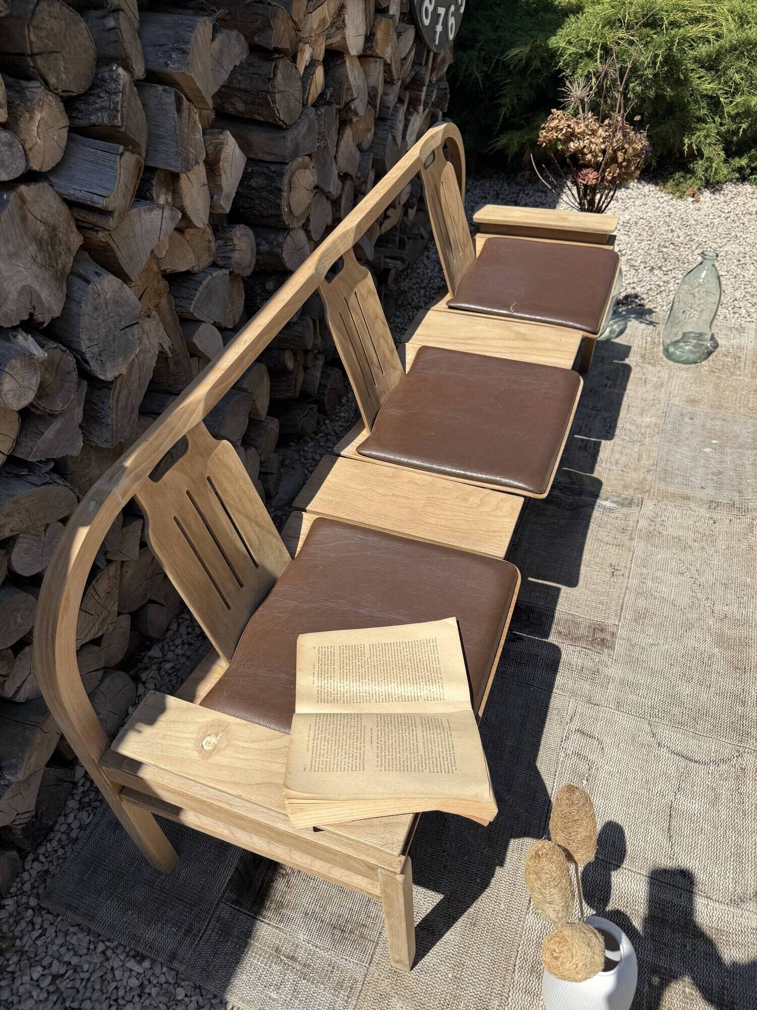 Baumann bench with wooden frame and faux leather seat.