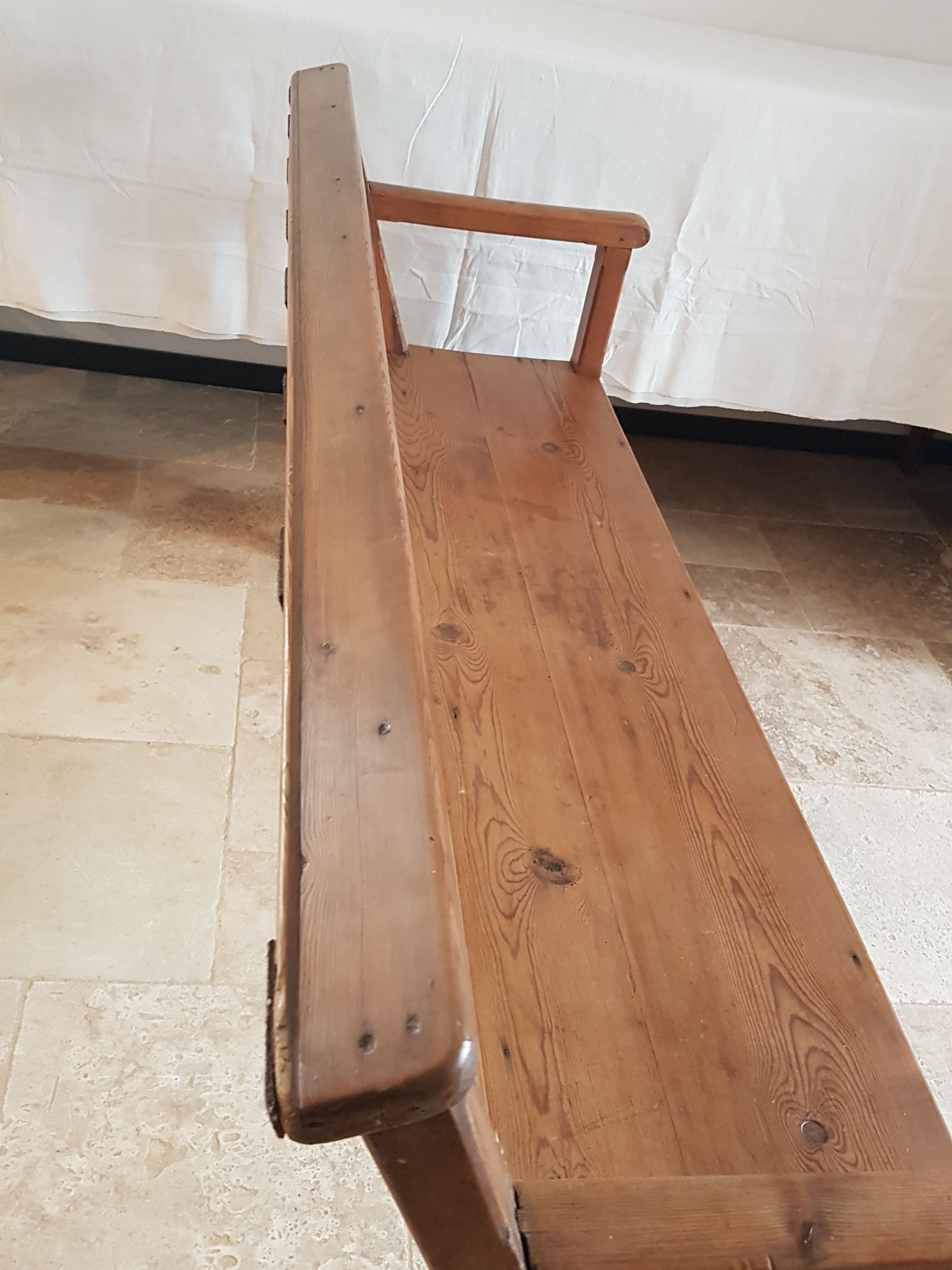 Church bench in fir tree with armrests