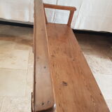 Church bench in fir tree with armrests