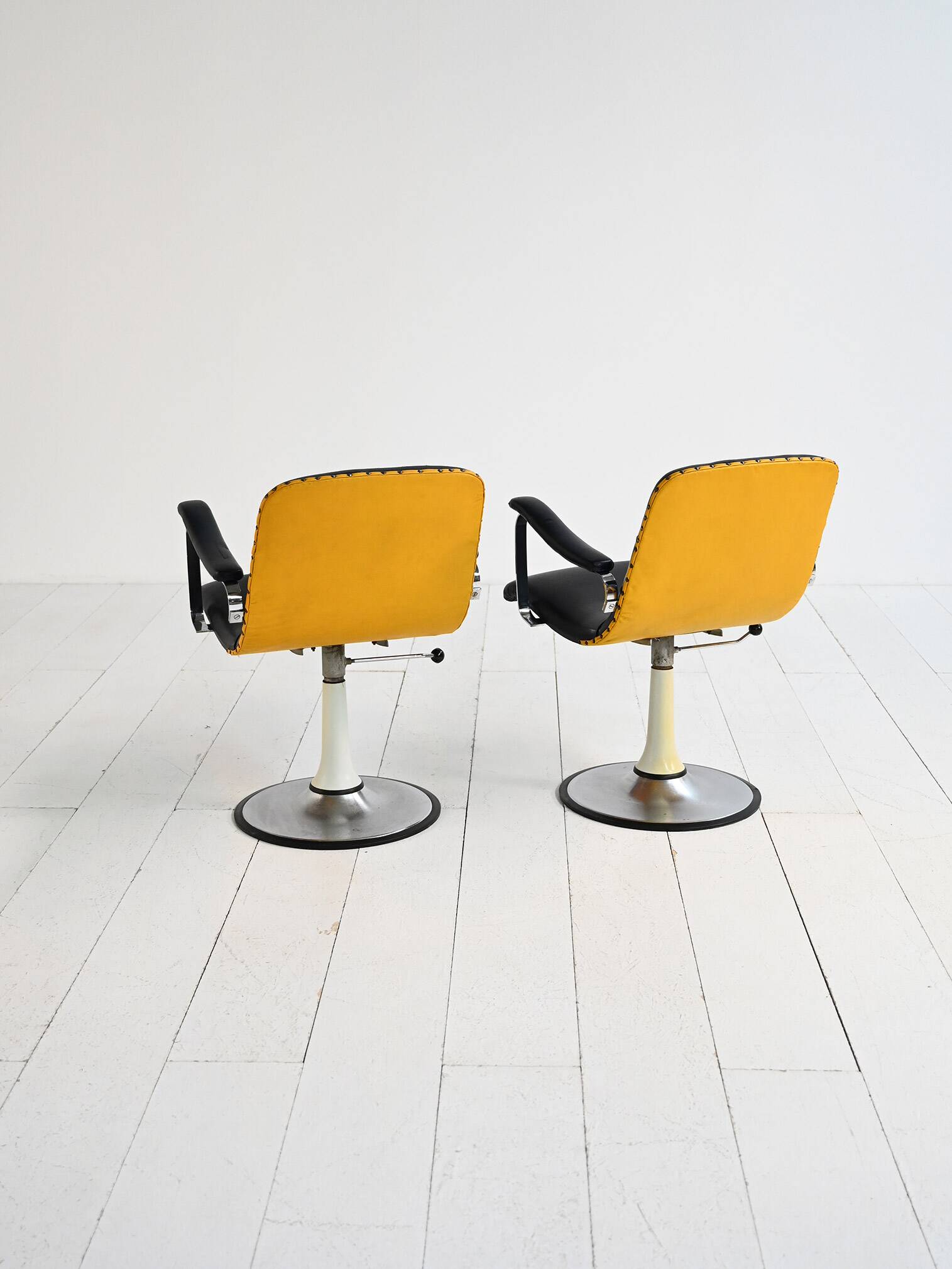 Pair of European 1970s swivel armchairs in faux leather and steel