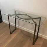 Console en acier brossé et laiton et plateau formé d'une dalle de verre. Travail français. Vers 1970