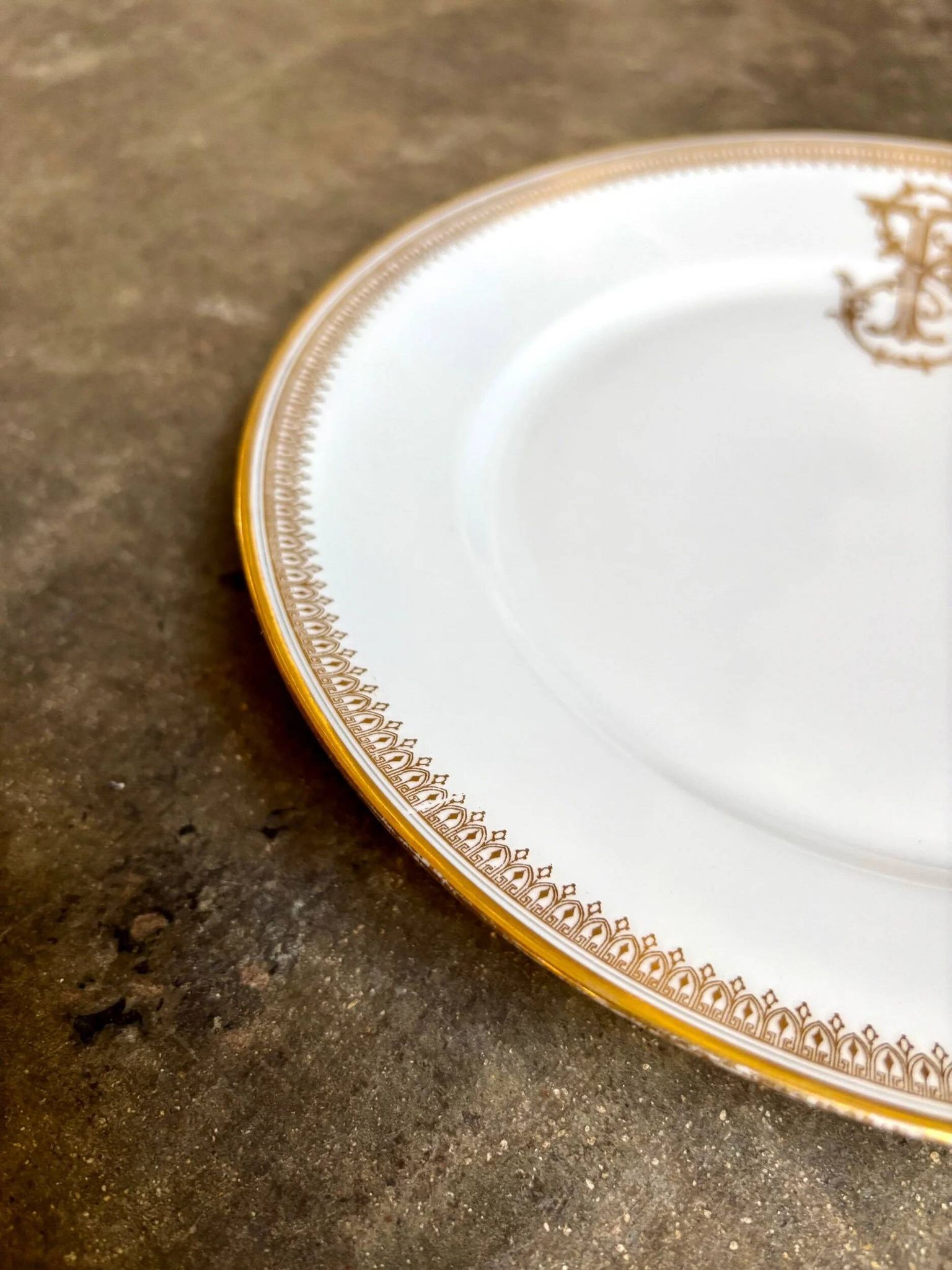 Assiette plate en porcelaine dorée monogrammée "F"