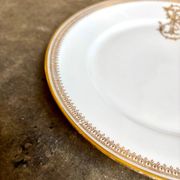 Assiette plate en porcelaine dorée monogrammée "F"
