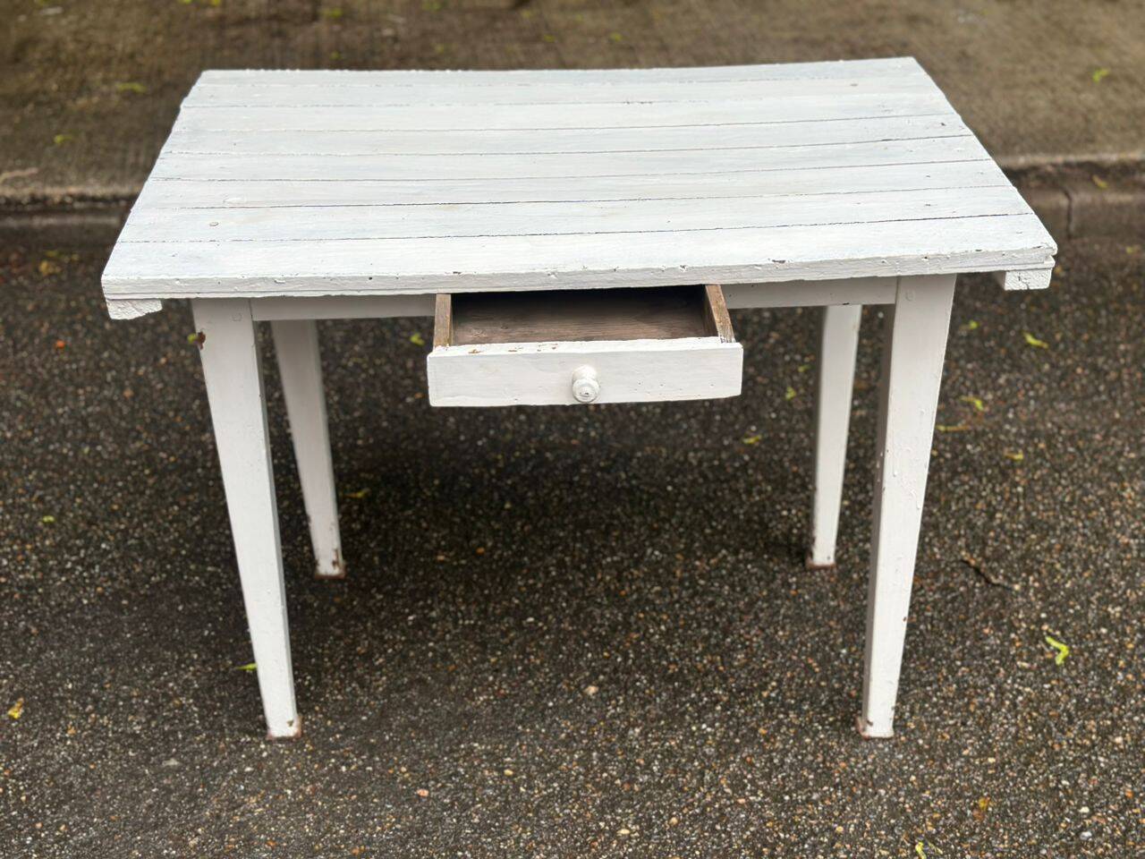 Vintage white wooden kitchen table with drawer from the 19th century.
