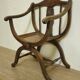 Fauteuil curule de style Art Nouveau en noyer sculpté et assise cannée