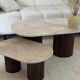 Oval coffee table duo travertine and fluted wooden legs.