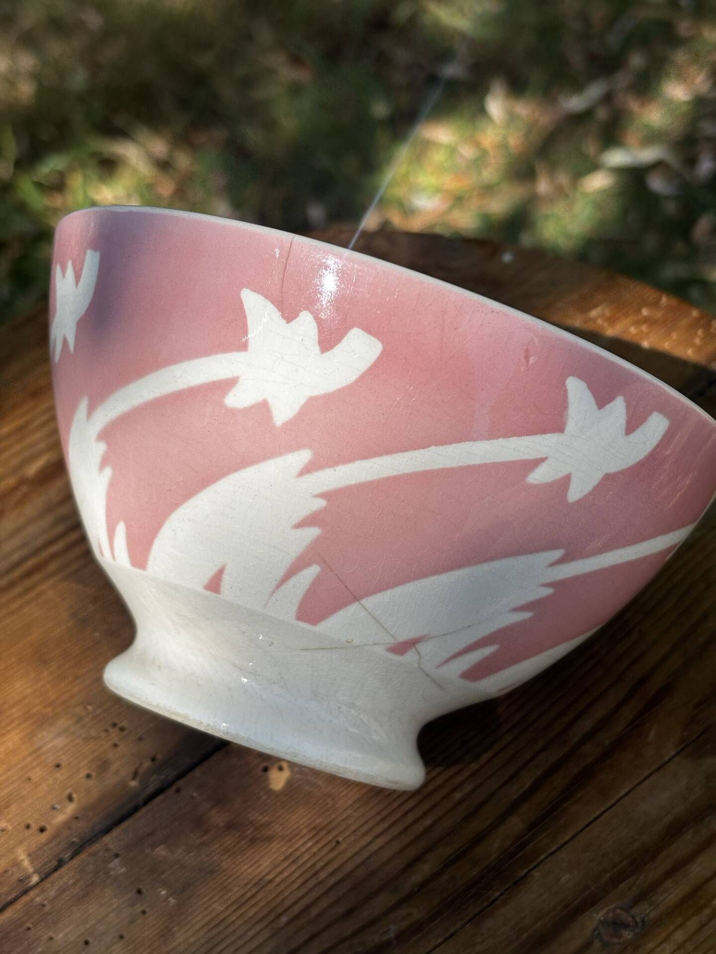 Old footed bowl in earthenware with pink decoration and defects.