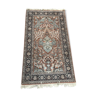 Tapis en laine et soie à décor végétalisé sur fond rose bordure à fond bleu 157 x 91 cm